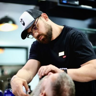 Barbeiro finalizando acabamento de um cliente na Barbearia Lumberjack, Uberlândia